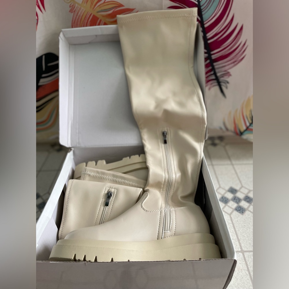 Beige flat form knee boots.